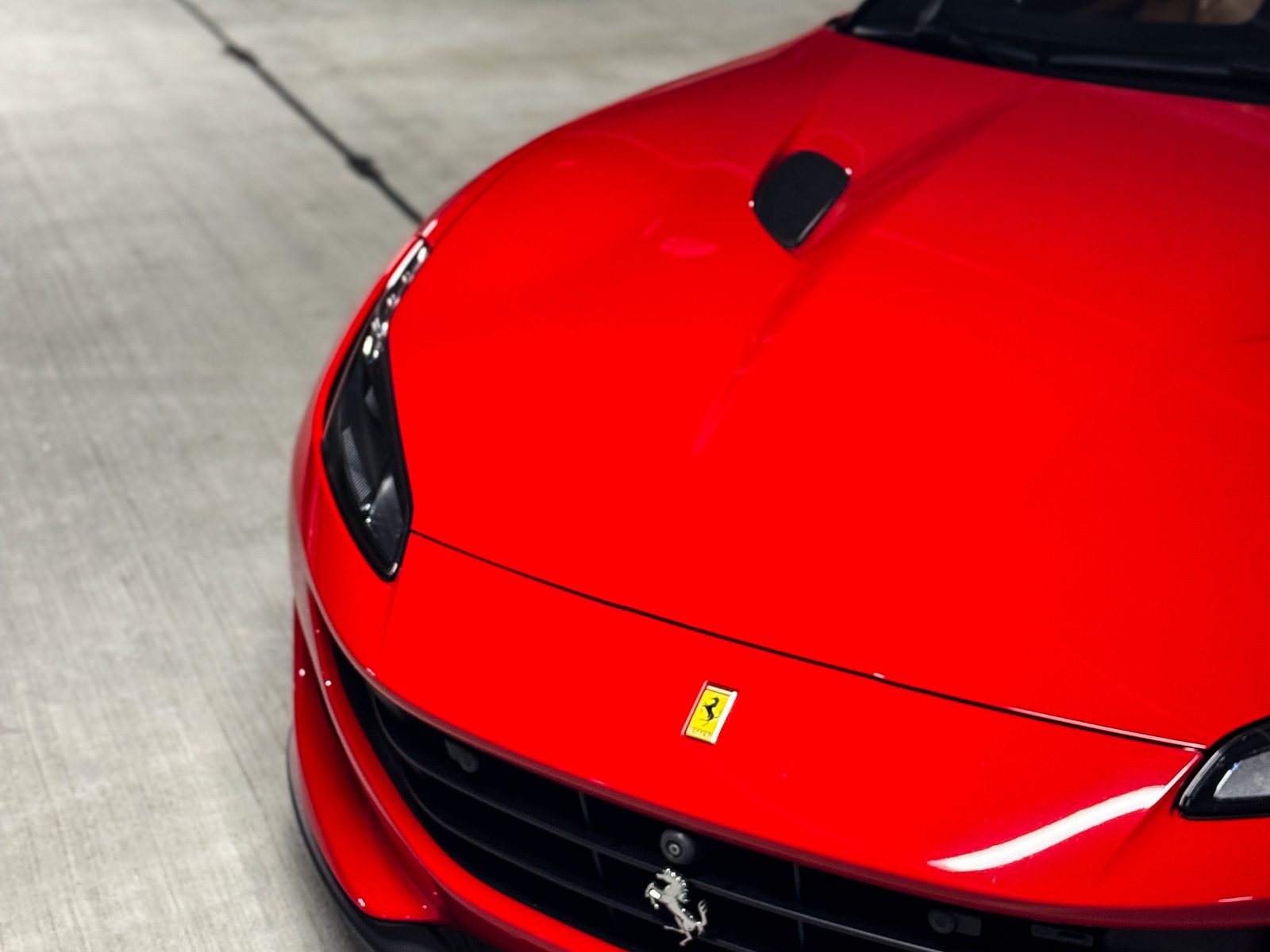 Front end of a red Ferrari, the area paint protection film covers