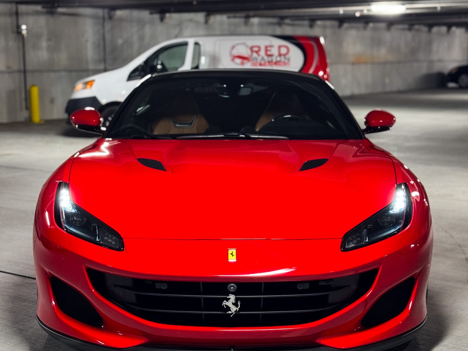 Red Ferrari convertible in a garage with the Red Wagon van behind, Red Wagon Detailing Charlotte NC